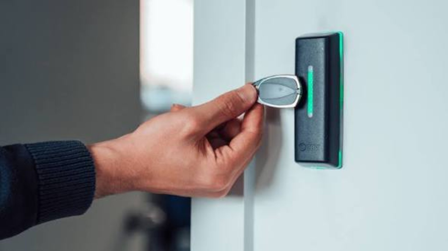 Porte-clés présenté à un lecteur d’accès installé près d’une porte