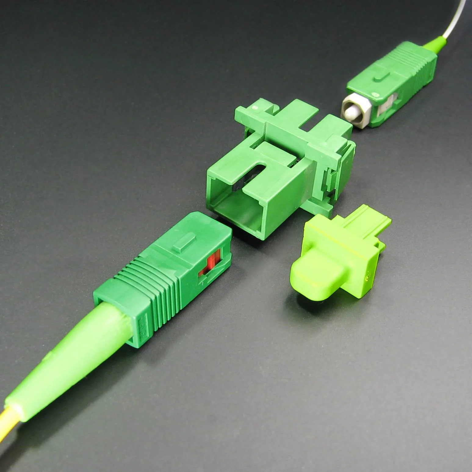Deux vues d’un connecteur de fibre optique SC vert sur fond clair